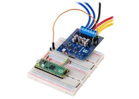 A Raspberry Pi Pico on a breadboard using a Motoron M2S shield to control motors.  A voltage regulator soldered to the Motoron powers the Pico.